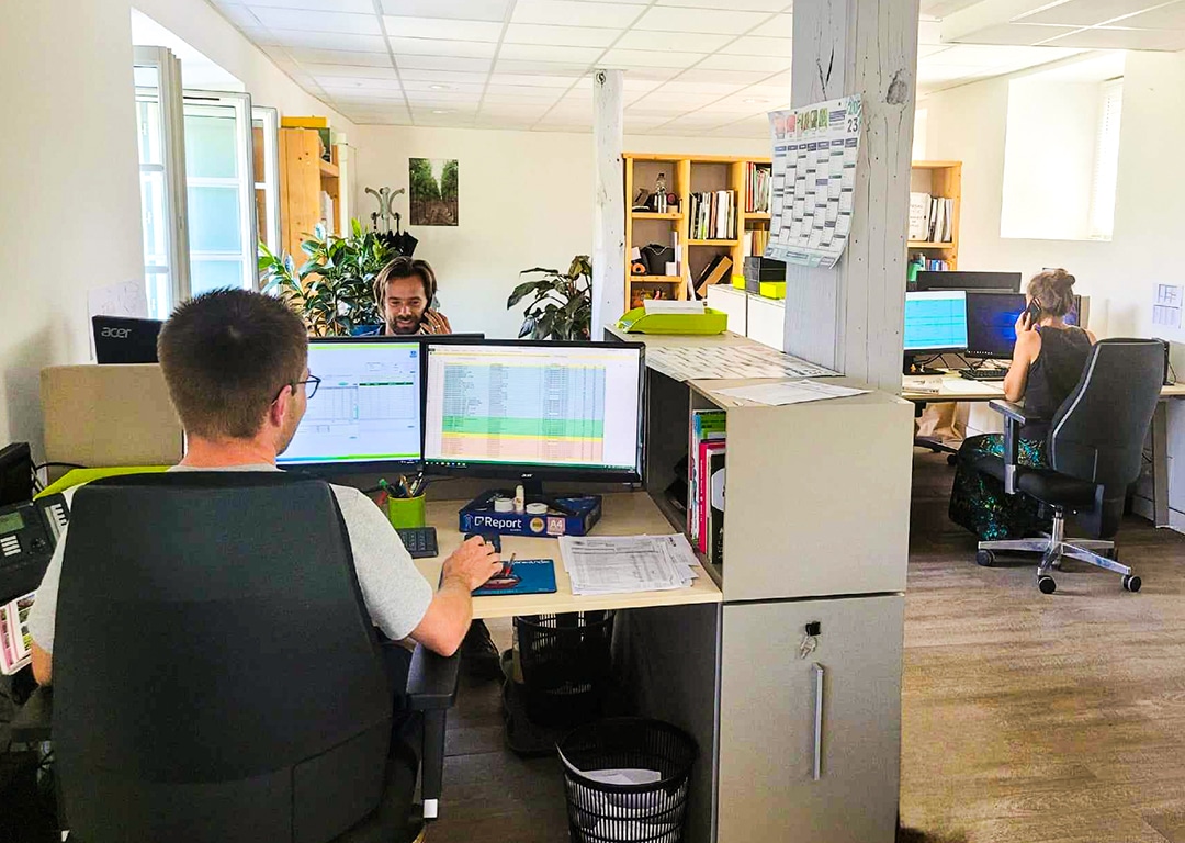 Bureau moderne avec employés travaillant sur ordinateurs.